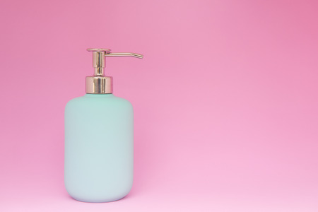 Minimal concept of blue shower gel, shampoo or cosmetic bottle on the colorful pink background with copy spaceの写真素材