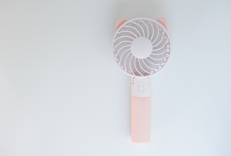 Pink portabe fan on the white background