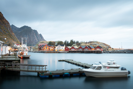 Long exposure of dock with speed boat and fishing rorbuer house village in Lofoten island Hamnoy Norwayの写真素材