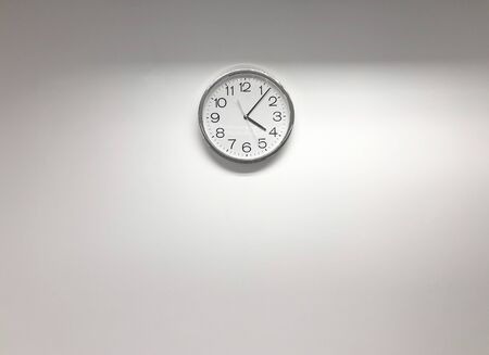 White modern clock on the white wallの写真素材