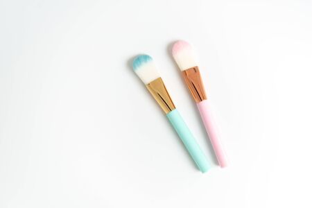 Flat lay of creative female decorative cosmetic for pink and blue cheek brush on the white isolated background with copy spaceの写真素材