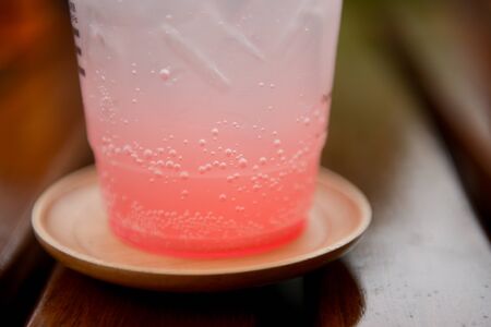 Close up bubble of the glass of pink sparking drink