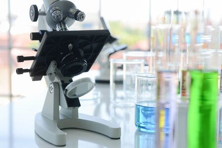Close up of electron microscope and glass laboratory chemical with chemical compounds inside in...