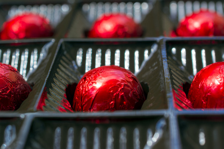 Photographed chocolates wrapped in red foil.の写真素材