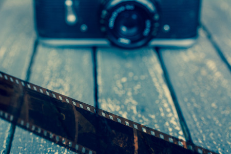 Old film and camera on a wooden background.の写真素材