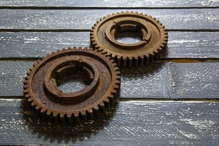Old rusty gears on a wooden table set in the shape of number eight.の写真素材