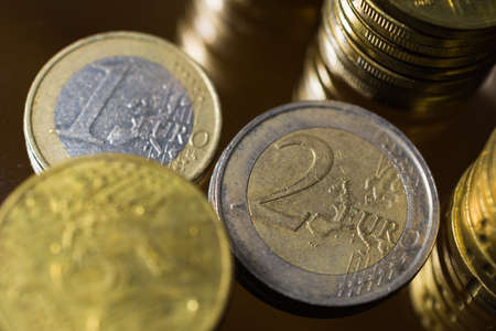 Euro coins and many coins stacked on top of each other.の写真素材
