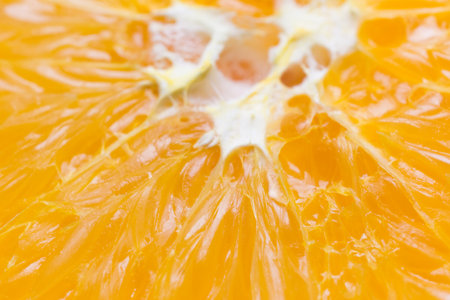 Cropped orange up close placed on an orange background.
