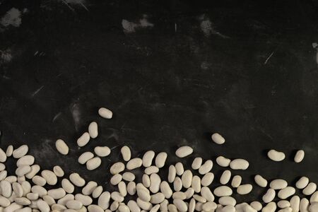 selective focus, white clean beans on black textural background, horizontal position, space for textの写真素材