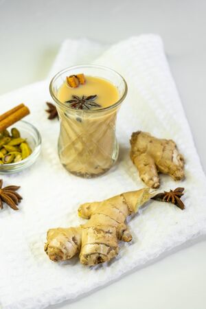 selective focus, Indian masala tea on a white background on a starched napkin, with spices of cinnamon, ginger and anise. Warming hot tea with spicesの写真素材