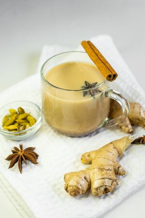 selective focus, Indian masala tea on a white background on a starched napkin, with spices of cinnamon, ginger and anise. Warming hot tea with spicesの写真素材