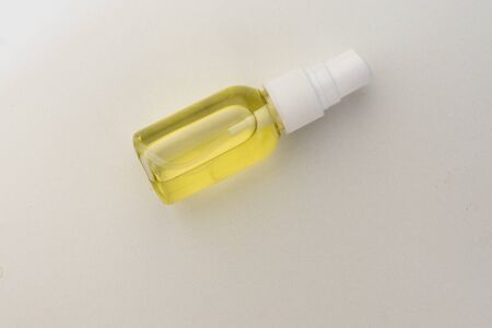 selective focus, transparent plastic spray jar with yellow cosmetic oil for body, face or hair