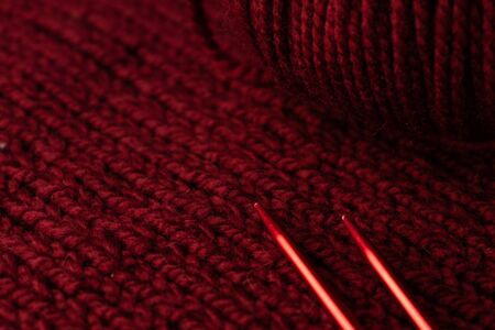 knitted with thick dark red threads, fabric and spokes, copyspace, macroの写真素材