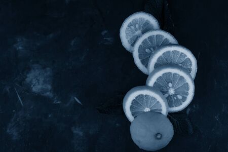 selective focus, yellow lemon rings on dark background, in the classic tinted blue, pantoneの写真素材