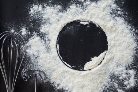 selective focus, copyspace, circle in flour on a dark background with kitchen accessoriesの写真素材