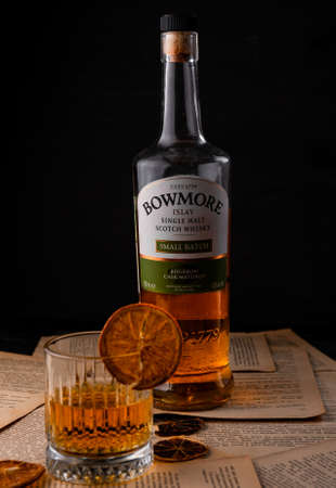 transparent glass of rye pure whiskey single malt, on pages from books, on a dark background