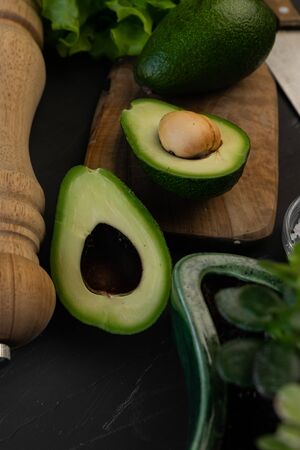 vegetarian green avocado cut in half on a wooden Board, with greens