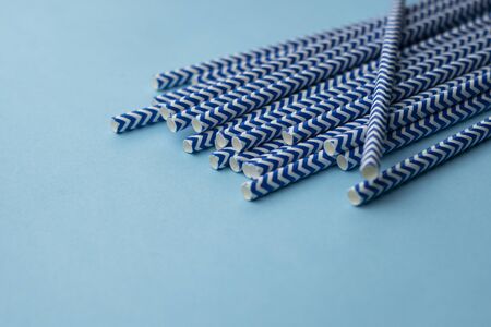 paper blue tubes for cocktails and drinks, copyspace, on a blue backgroundの写真素材