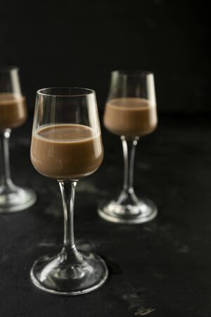 selective focus: chocolate and coffee liqueur in a tall stack on a dark table