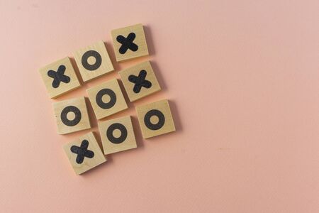 selective focus, wooden dice game TIC-TAC-toe on a paper colored background, copyspaceの写真素材