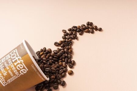 paper Cup with the words coffee, cappuccino, espresso. with coffee beans on a pink background, copyspaceの写真素材
