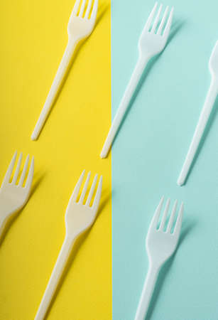 selective focus, plastic white forks on colored paper, pattern