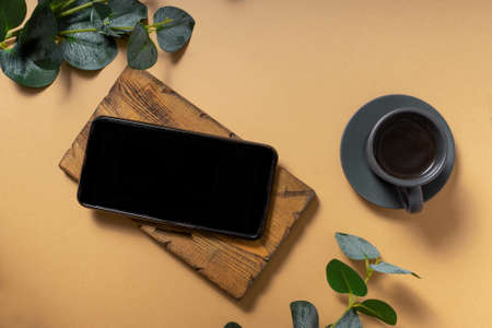 mockup, a mobile phone with a black screen on a plain background. flatlay, top view. with a small...