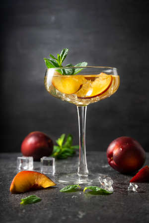 author's cocktail with nectarine fruit in a high martini glass. low key, vertical position. Concept for menus and barsの写真素材