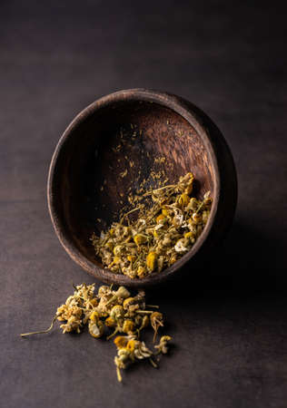 natural green leaf tea. chamomile in a wooden bowlの写真素材