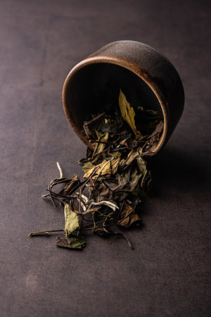 selective focus, natural green leaf tea. brewing in a clay bowl. vertical angle, macro. on a dark background. for menus and cafesの写真素材