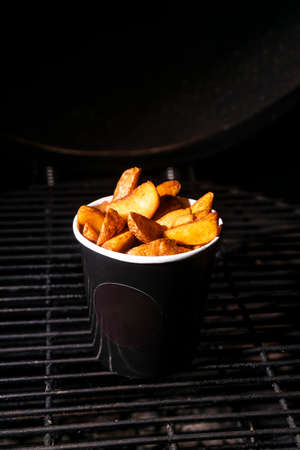 selective focus, French fries with salt and spices in a craft black mock up cup. Low Keyの写真素材