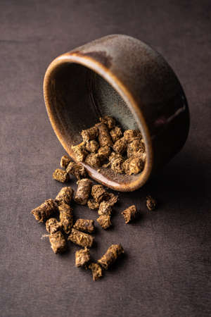 selective focus, natural green leaf tea. brewing in a clay bowl. vertical angle, macro. on a dark background. for menus and cafesの写真素材