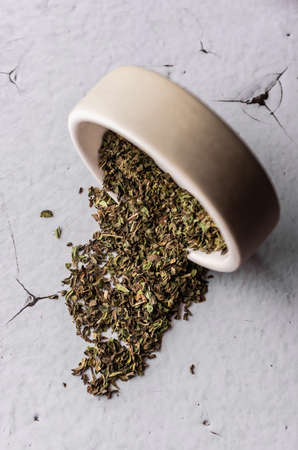 selective focus, natural green leaf tea. brewing in a clay bowl. vertical angle, macro. on a light background. for menus and cafesの写真素材