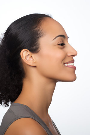 Side view portrait of a beautiful young asian woman smiling against white backgroundの素材