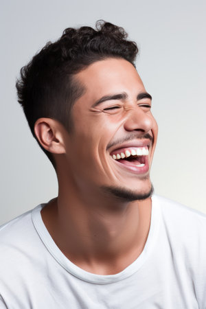 Portrait of a happy young man laughing isolated on a white backgroundの素材