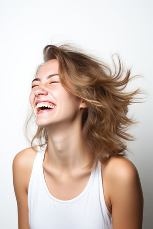 Portrait of a beautiful young woman with flying hair on white backgroundの素材