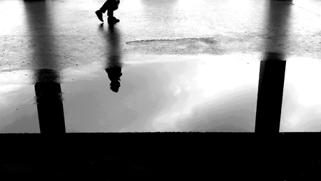 man reflected in a puddleの写真素材
