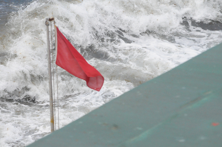 red flag of sea big dangerの写真素材