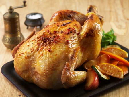 Roast chicken and various vegetables on wooden plateの写真素材