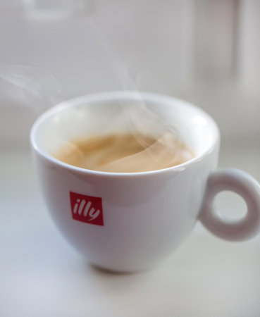 Riga, Latvia - November 22, 2015: Cup of illy espresso coffee on white table. Illycaffe is a worldwide coffee roasting company, its espresso is very popular in Latvia and EU.のeditorial素材