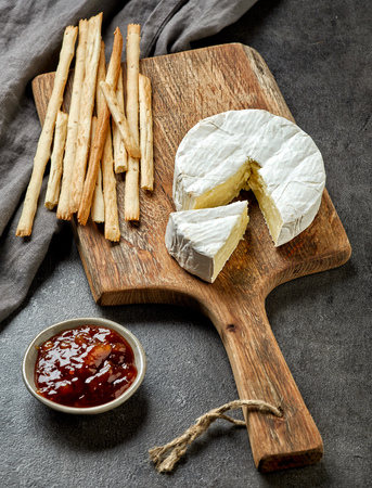 fresh camembert cheese on wooden cutting boardの写真素材