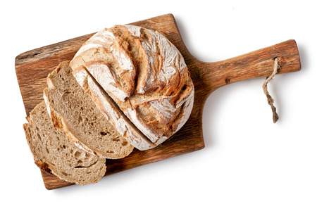 freshly baked bread on wooden cutting board isolated on white background, top viewの写真素材