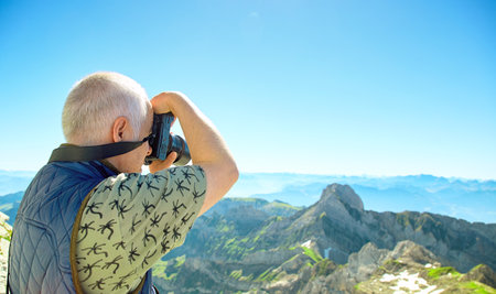 Saentis, Switzerland - JULY 17, 2017: A traveler tourist with photo equipment shooting panorama of Swiss Alps.のeditorial素材