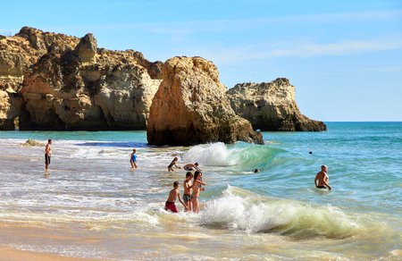 Portimao, Portugal -  October 22, 2017: Wiew of Algarve beach and Atlantic Ocean, people are swiming and sunbasing, enjoing ocean waves and sunのeditorial素材