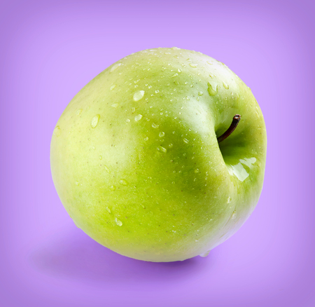 Wet green whole apple on ultra violet backgroundの写真素材