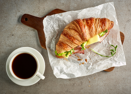 Croissant with ham and cheese on grey table, top viewの写真素材