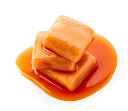 caramel candies and sauce isolated on white backgroundの写真素材