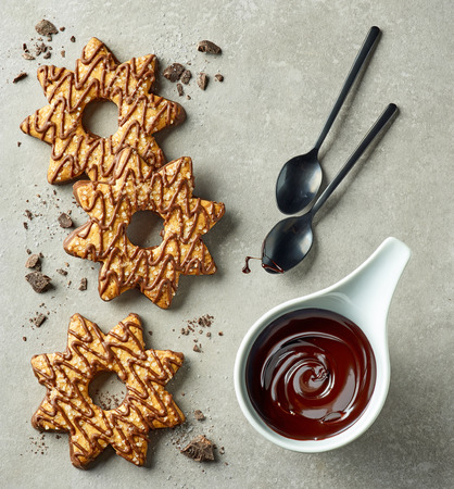chocolate sauce and star shaped cookies on grey background, top viewの写真素材