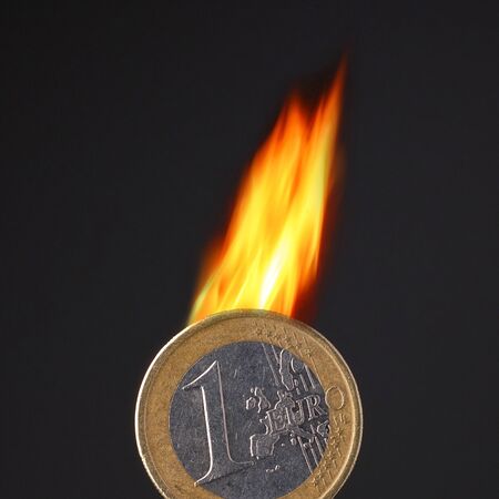 burning euro coin on black backgroundの写真素材