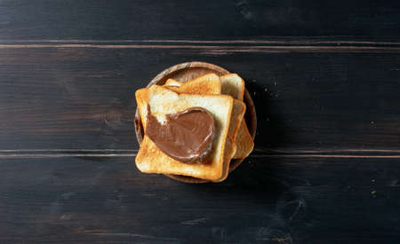toasted bread with chocolate cream on rustic wooden kitchen table, top viewの写真素材